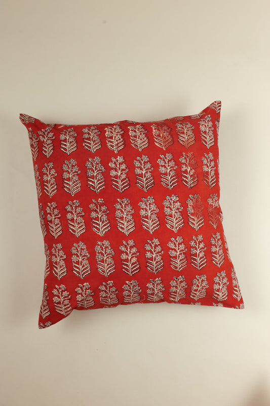 Red pillow with white floral pattern on a beige background