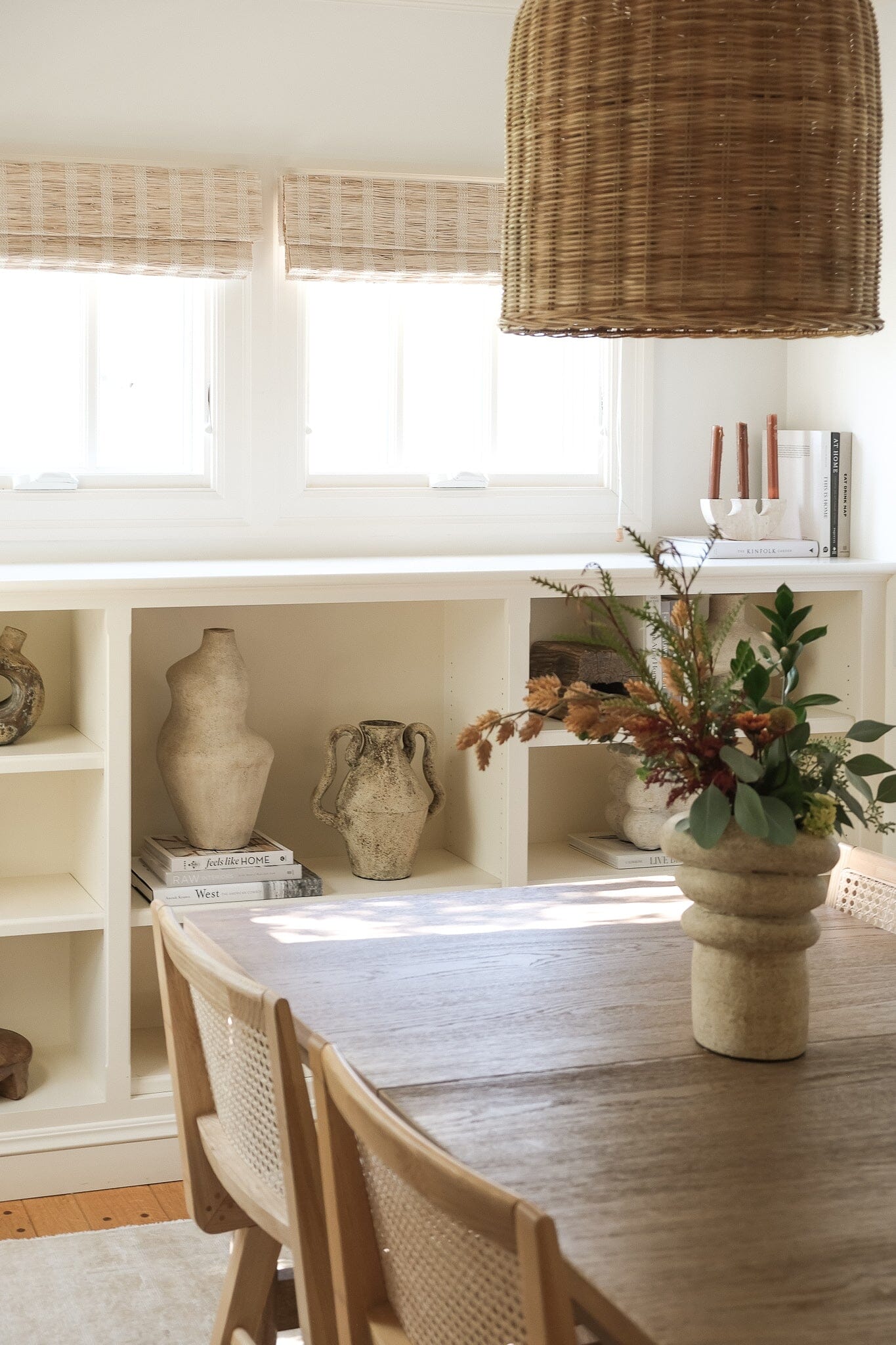 Dining room with wooden table, chairs, and decorative items.