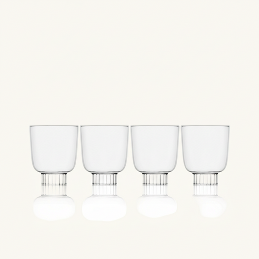 Set of four clear glass tumblers with metal bases on a white background