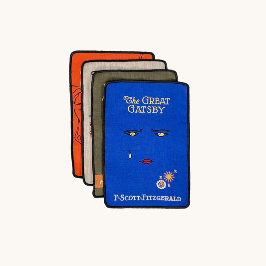Four book covers of 'The Great Gatsby' by F. Scott Fitzgerald on a white background