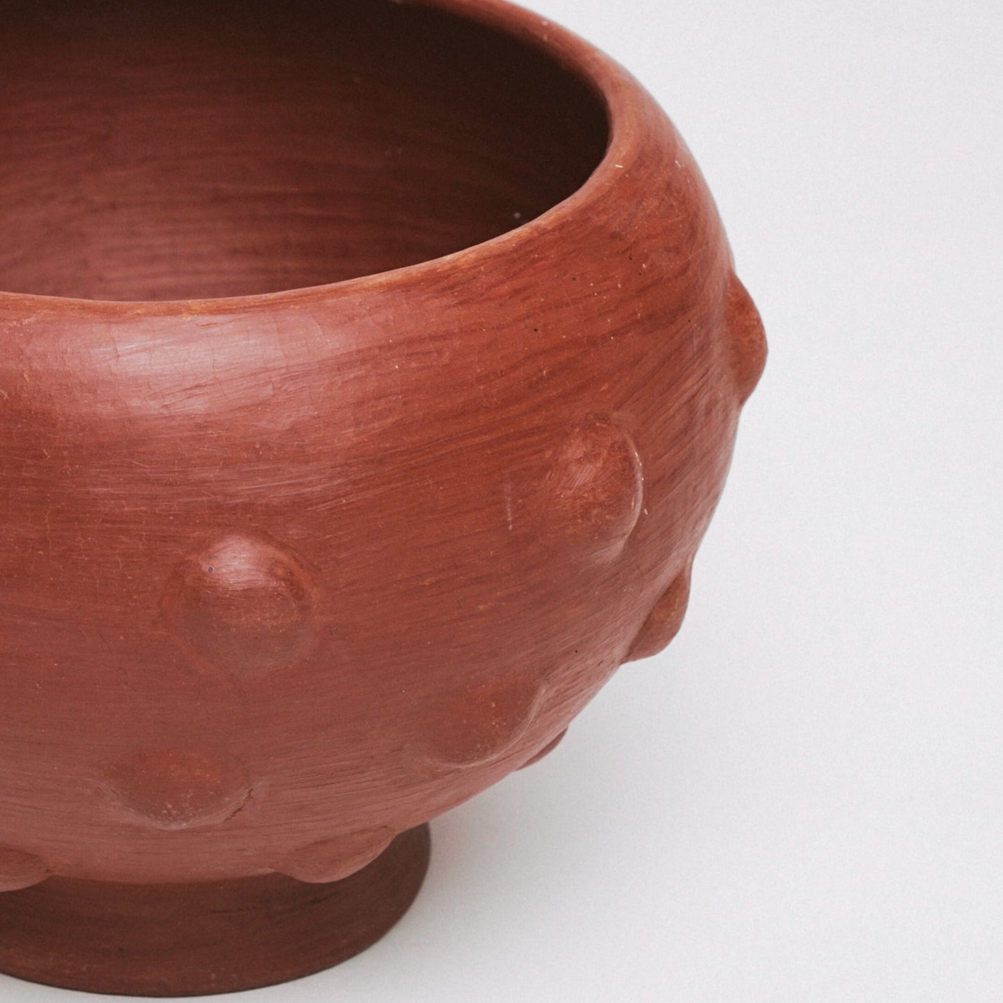 Terracotta pot with textured surface on a white background