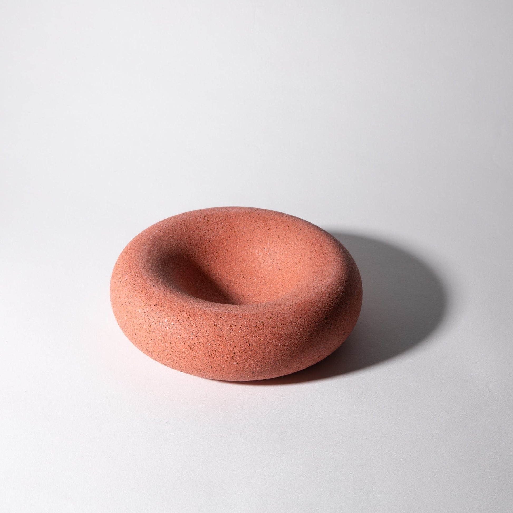 Terracotta-colored ceramic bowl on a white background