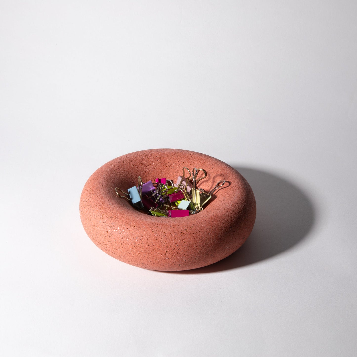 Red ceramic bowl with decorative elements on a white background