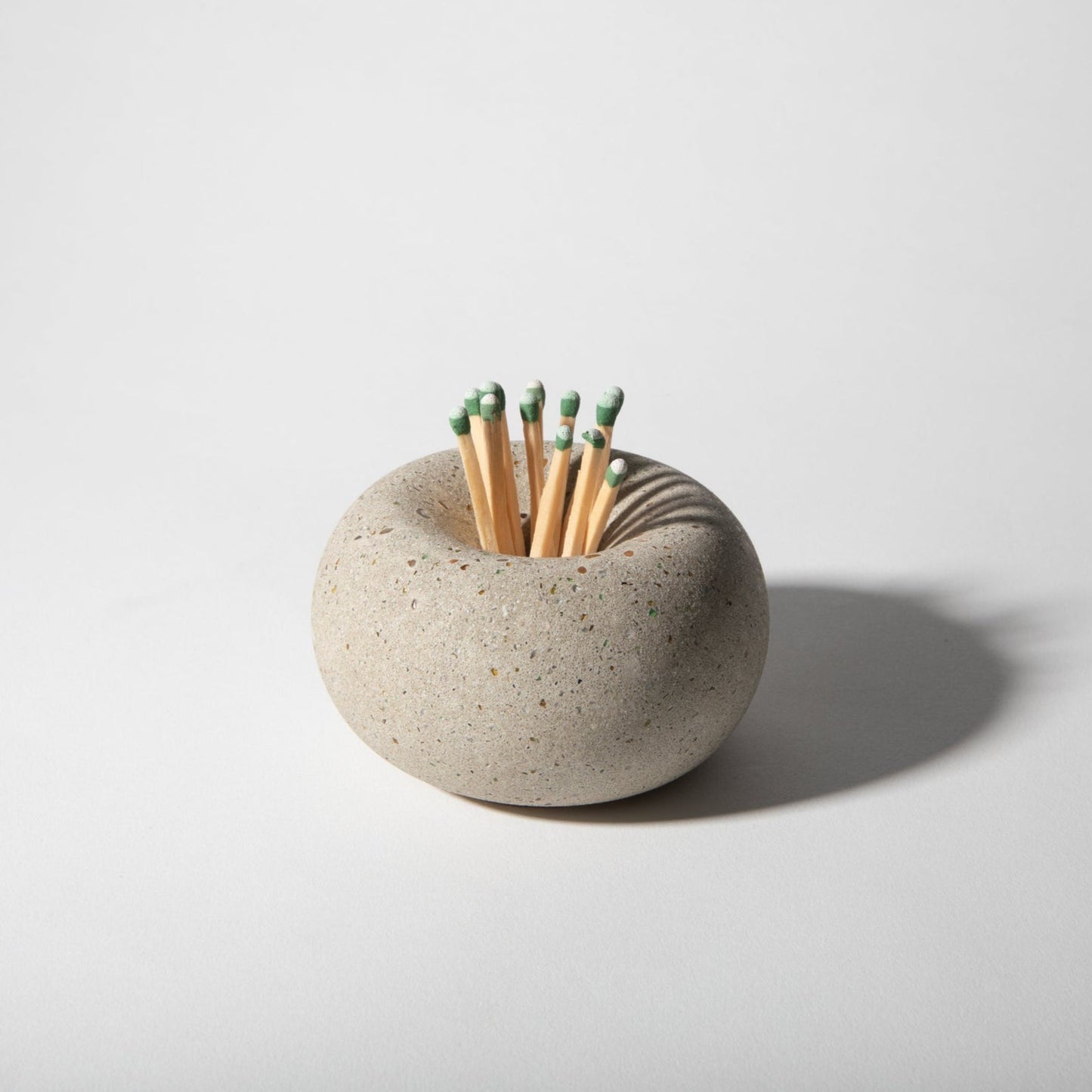 Ceramic match striker with matches on a light gray background