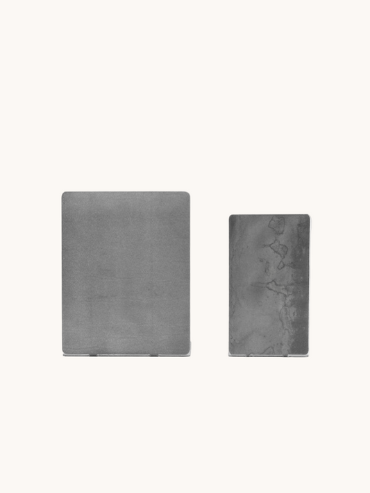 Two gray textured square objects on a white background