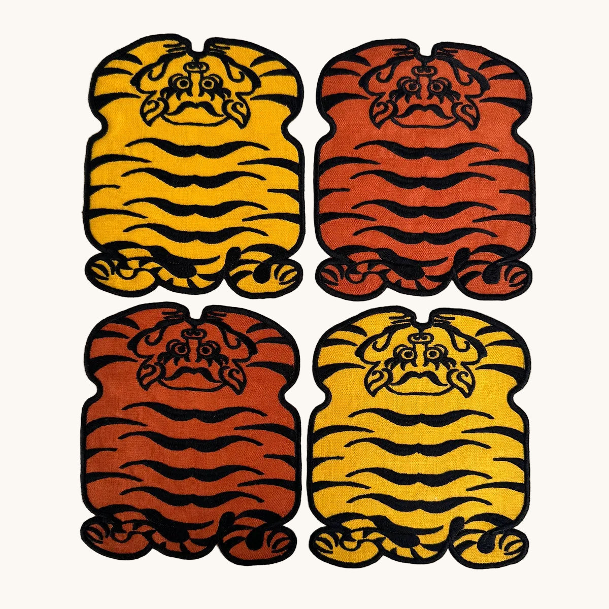 Four tiger-shaped stickers in yellow, orange, and brown on a white background