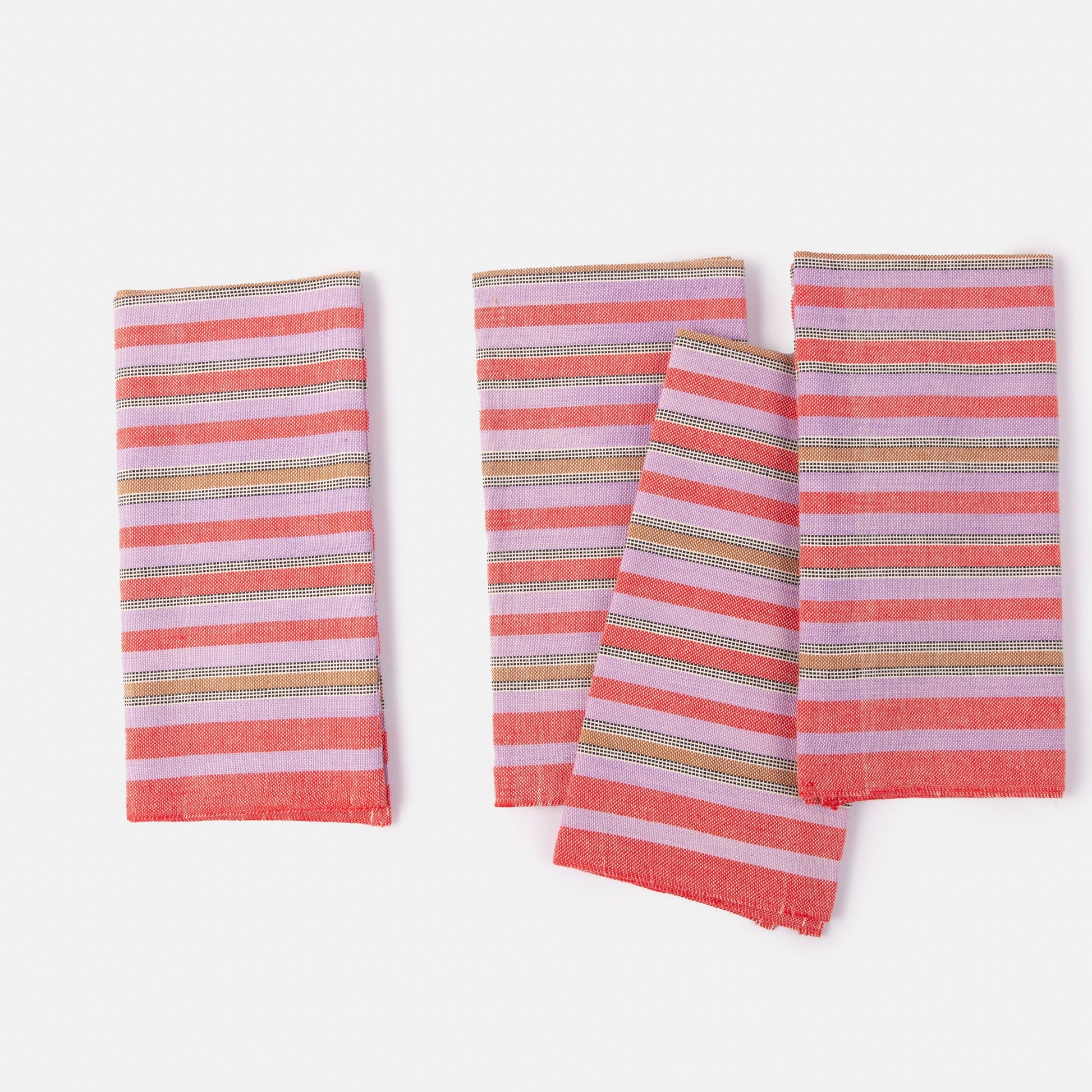 Set of three striped napkins with pink and multicolor pattern on a white background