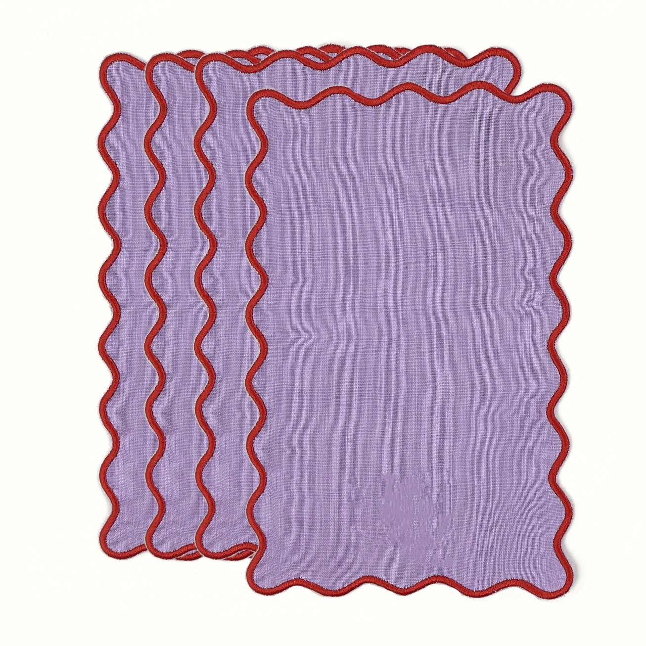 Set of three purple placemats with red scalloped edges on a white background