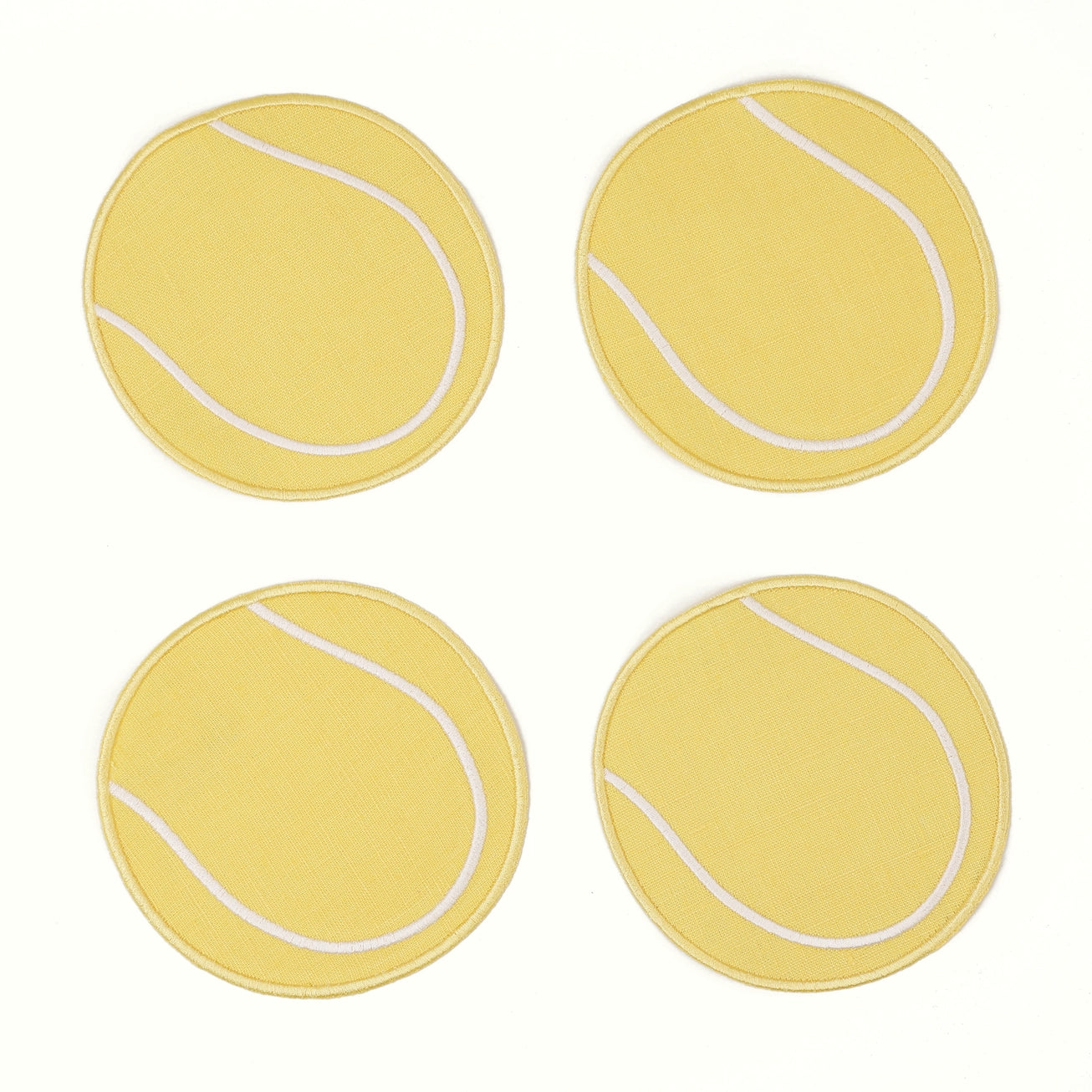 Four yellow coasters with white lines resembling tennis balls on a white background