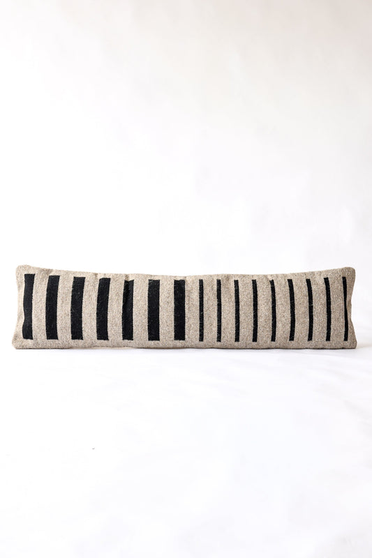 Striped pillow with black and beige pattern on a white background