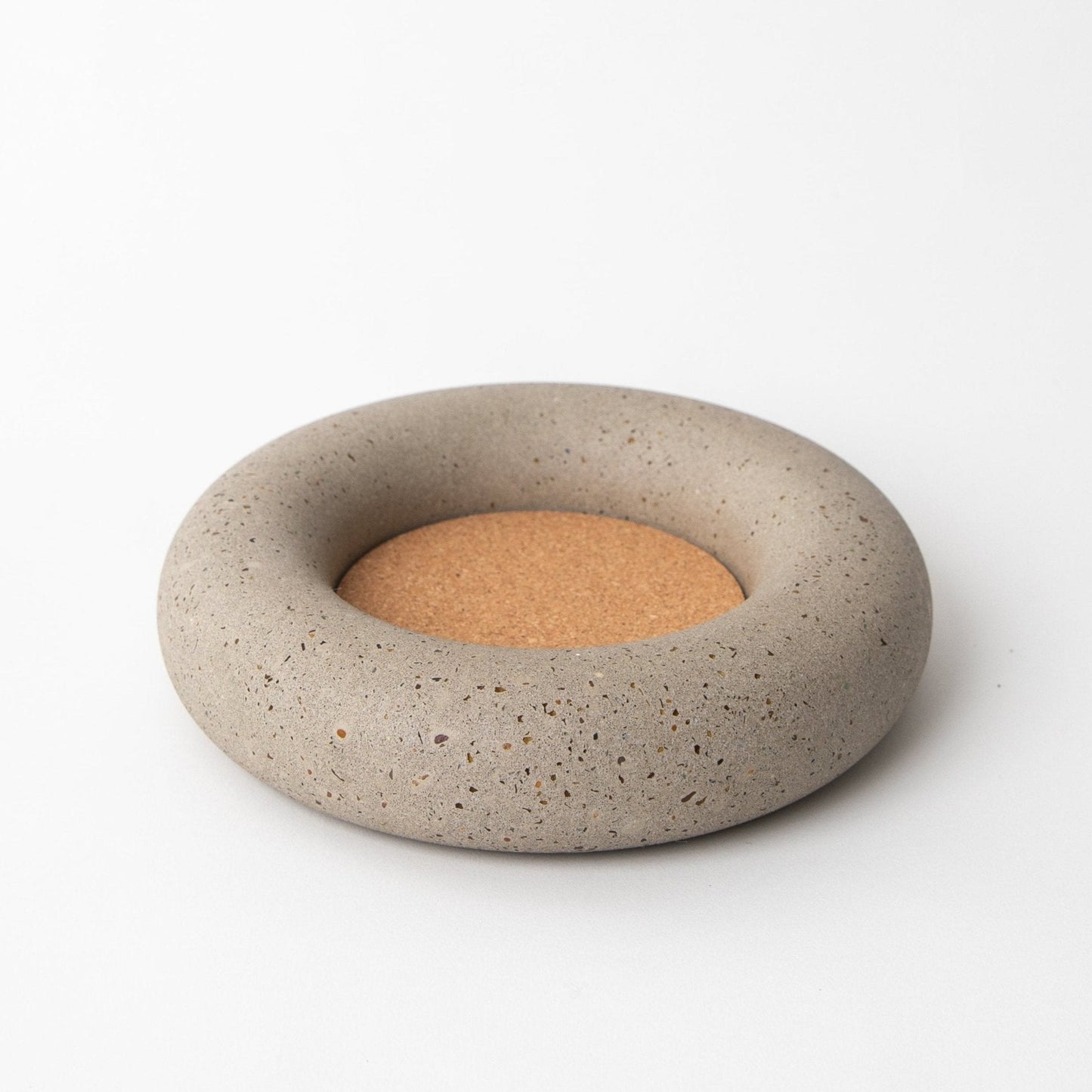 Concrete coaster with cork base on a white background