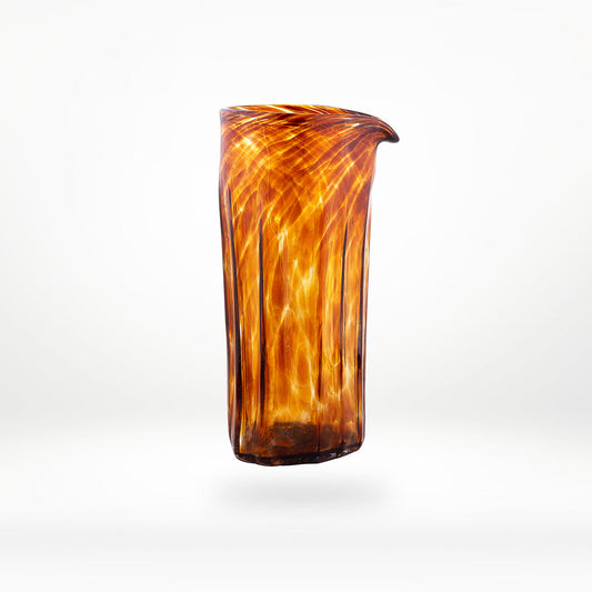 Decorative glass vase with brown and orange swirl pattern on a white background