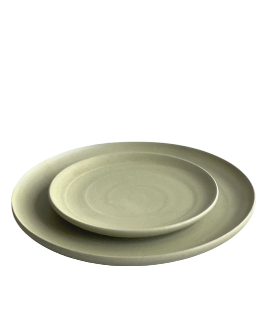 Two green ceramic plates stacked on a white background