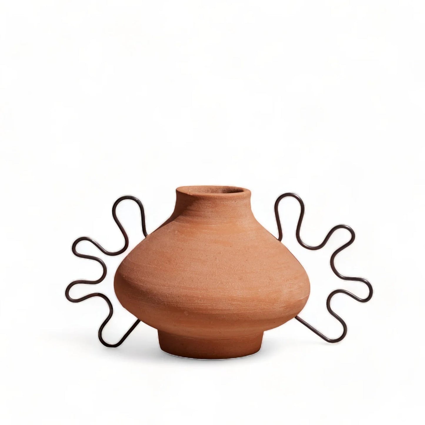 Terracotta vase on a decorative metal stand against a white background