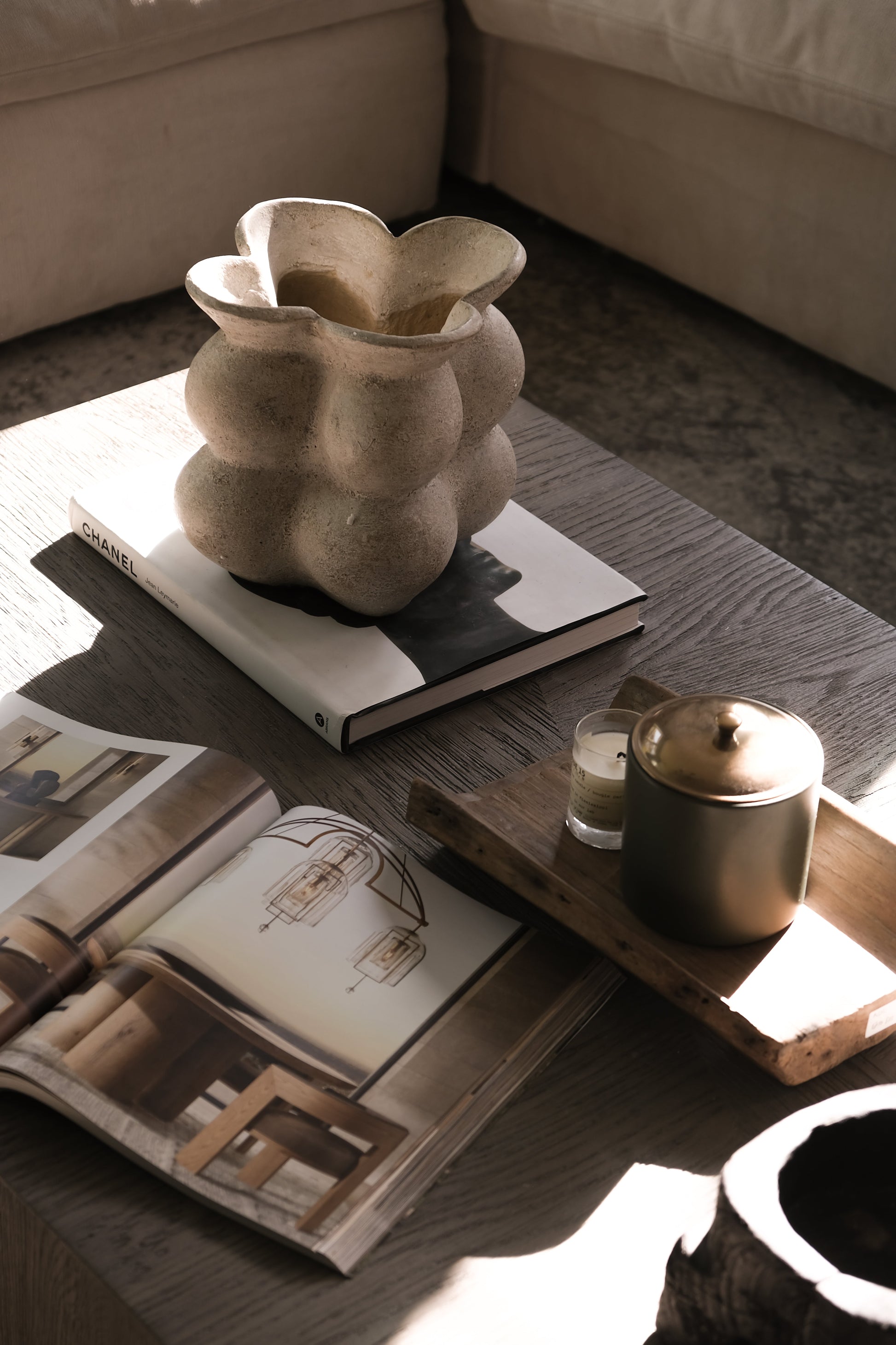 Decorative vase on a coffee table with a magazine and candle