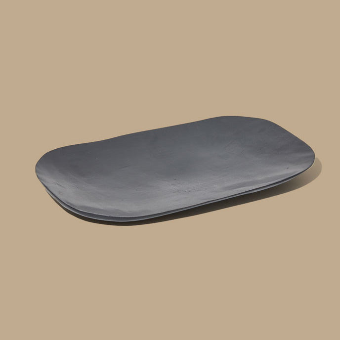 Black ceramic plate on a beige background