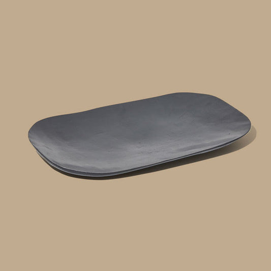 Black ceramic plate on a beige background