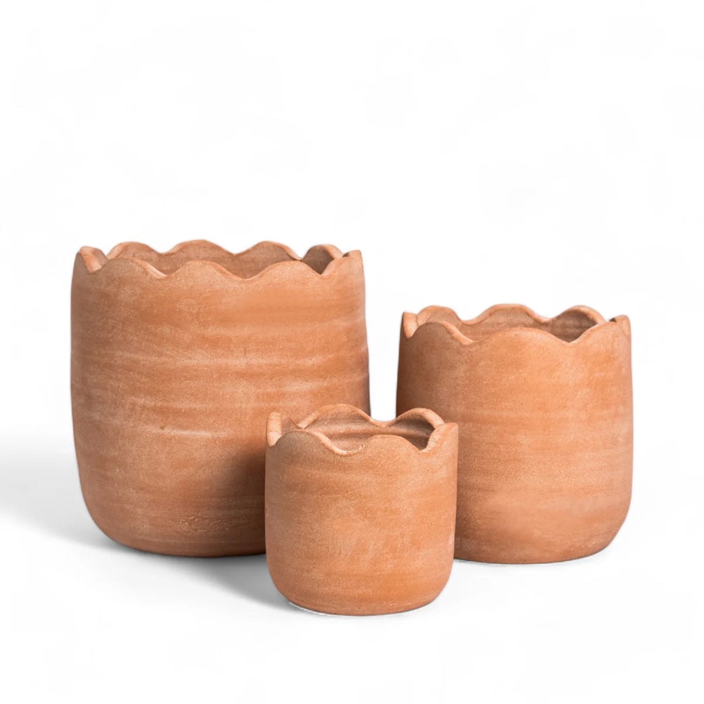 Three terracotta pots of different sizes on a white background