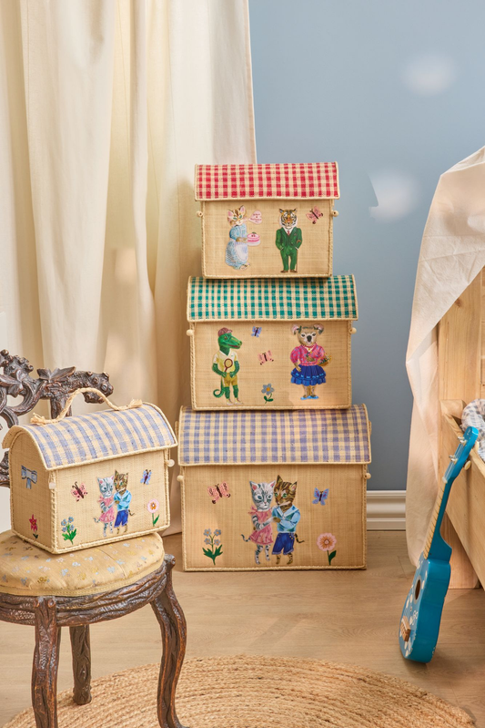 Stack of decorative storage boxes with cartoon bear designs on a wooden stool against a light blue wall.