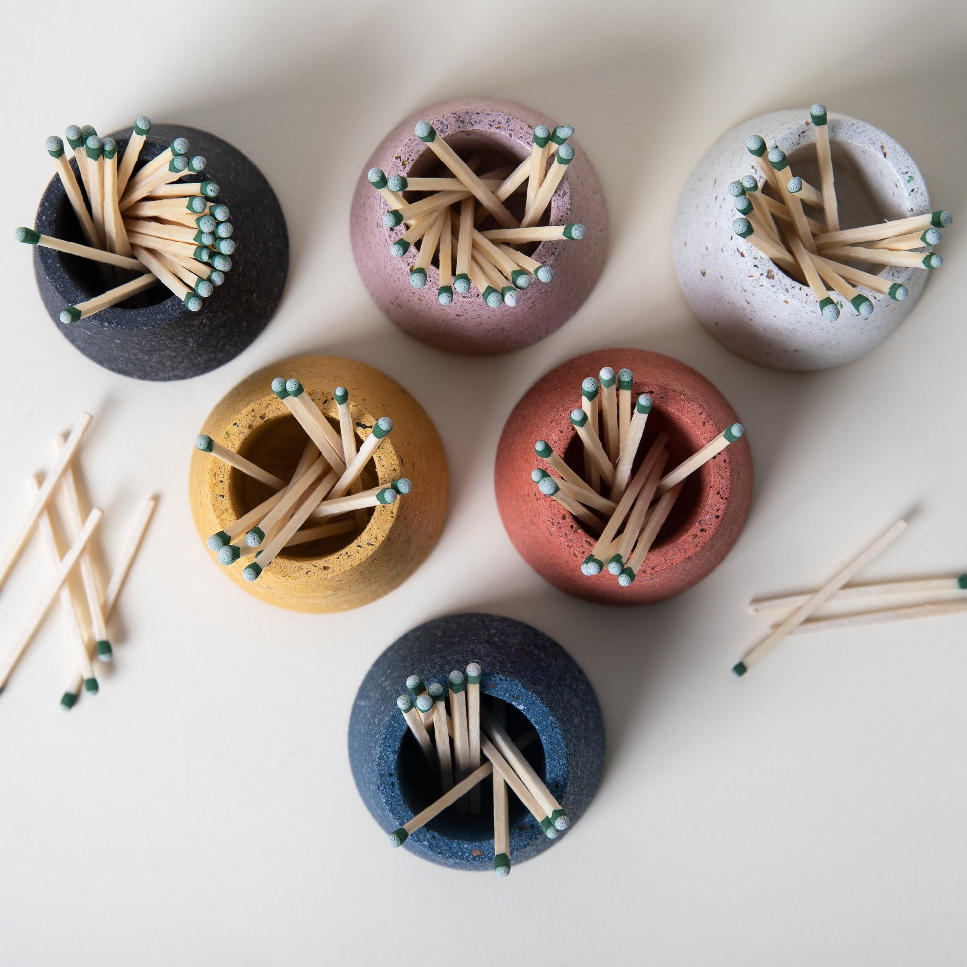 Set of colorful match holders with matches on a white background