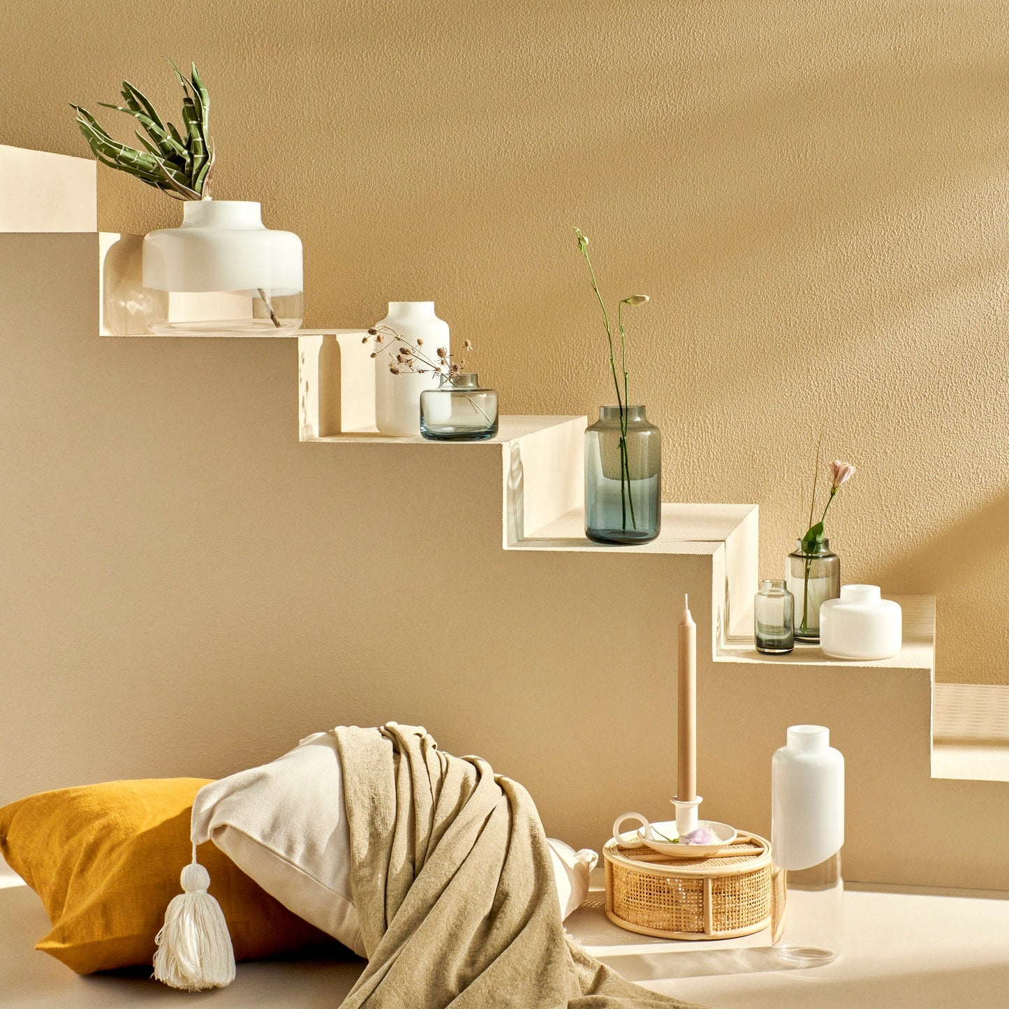 Decorative wall shelves with plants and vases against a beige wall.