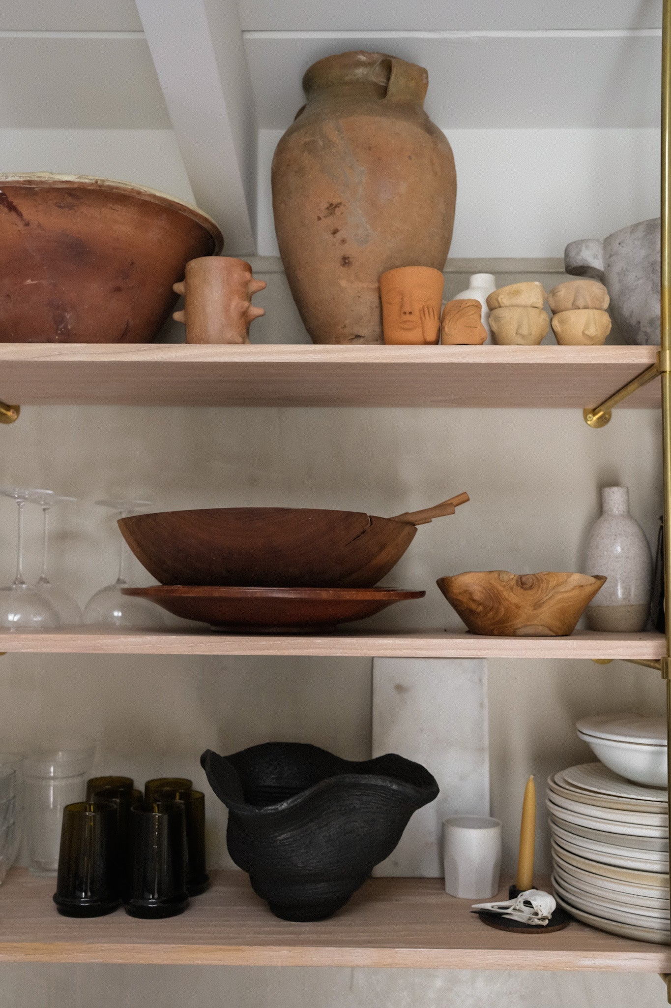 Shelves with various ceramic items including vases, bowls, and a mortar and pestle.