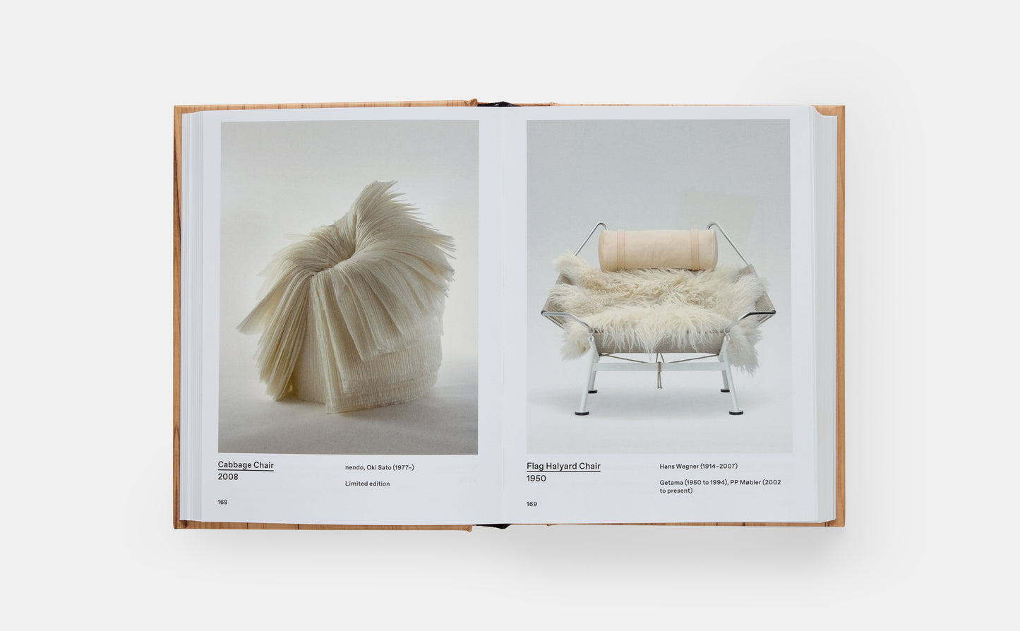 Open book displaying images of a modern chair and a sculpture on a white background