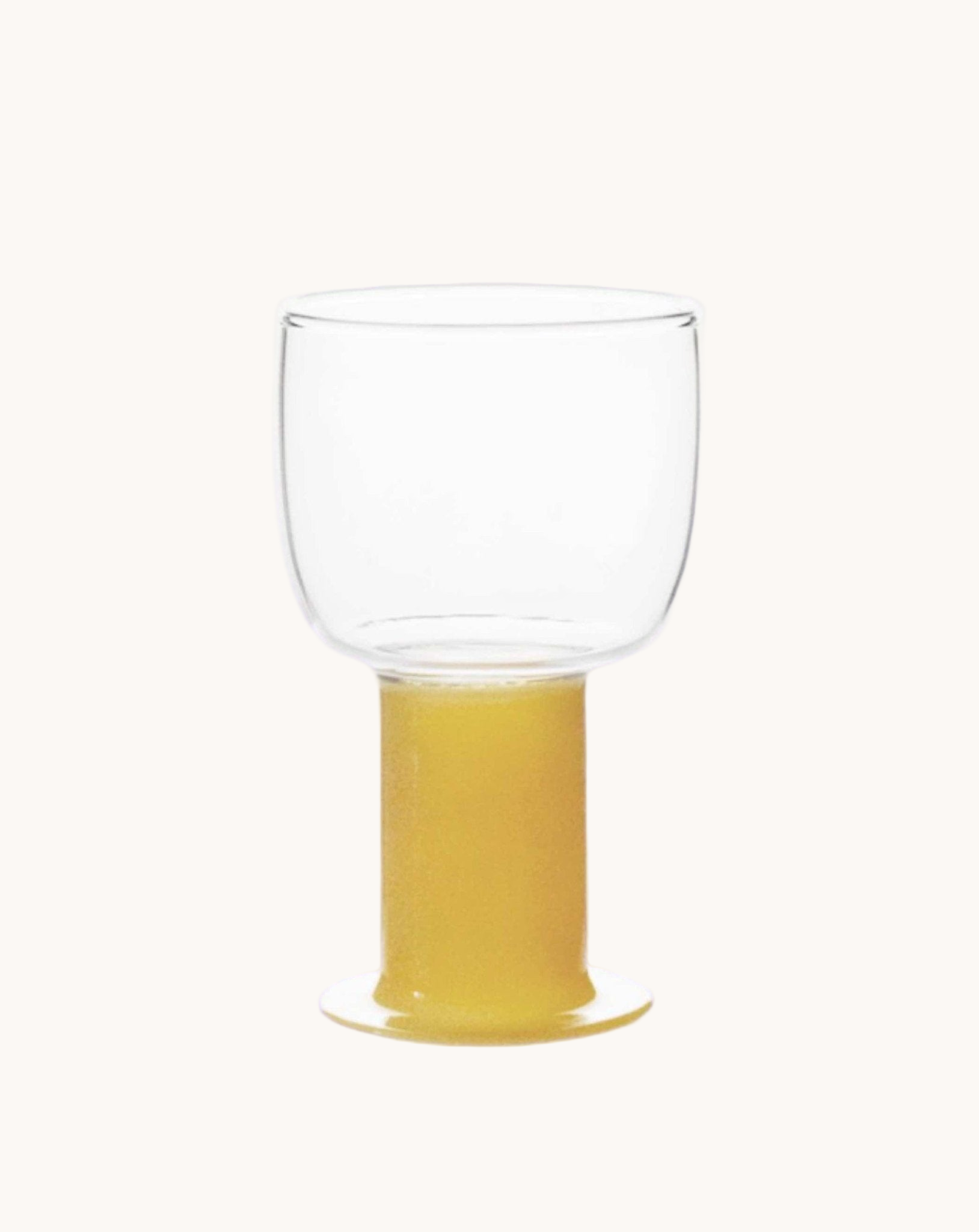 Clear glass with yellow liquid on a white background